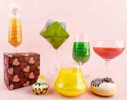 The image shows a colorful assortment of drinks and dessertsincluding glasses with vibrant liquids and decorated cupcakes and donuts