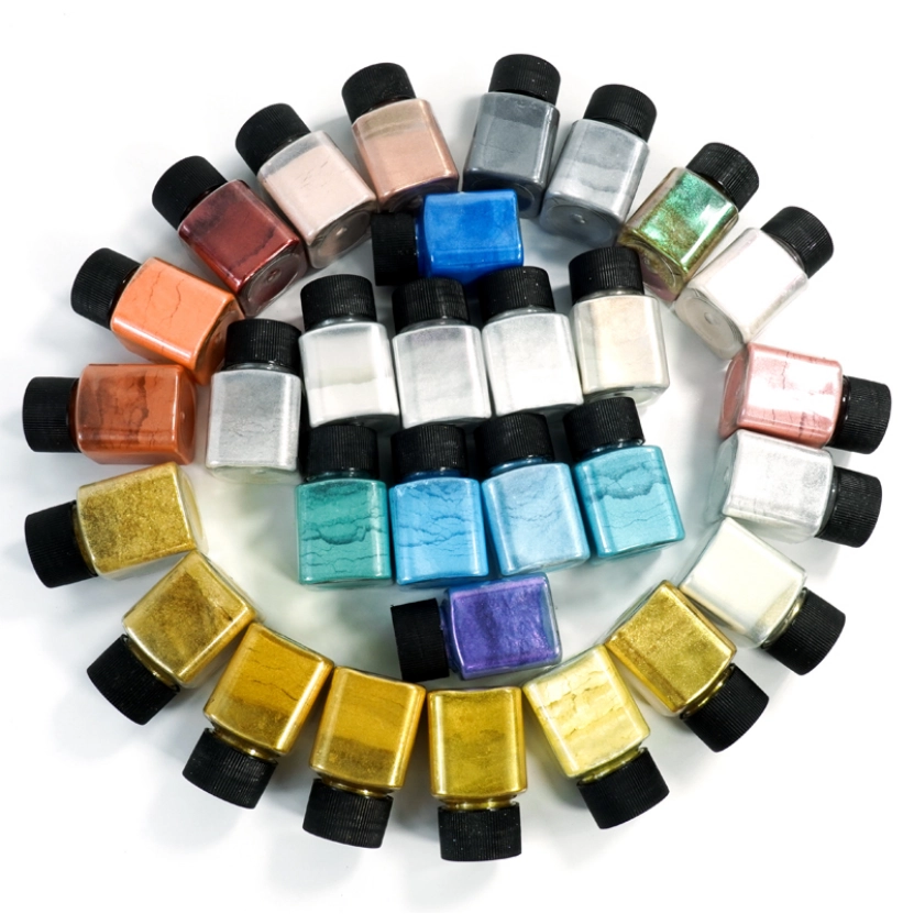 A collection of small jars filled with various colored glitter powders arranged in a circular pattern