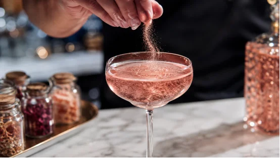 Adding rose gold edible glitter to sparkling wine